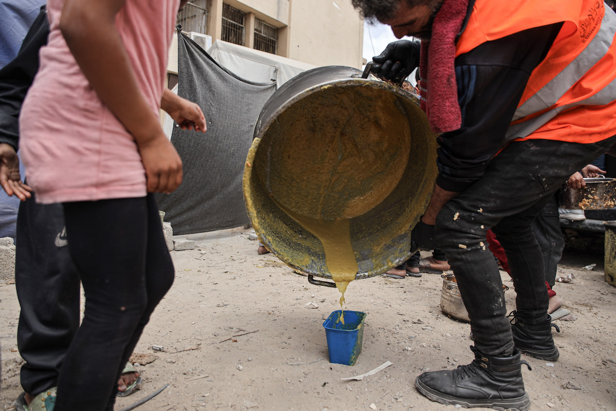 A charity organization distribute food and drinking water to Palestinians in the Jabalia area in the northern Gaza Strip, in Jabalia, Gaza on May 12, 2025. [Abdalhkem Abu Riash - Anadolu Agency]